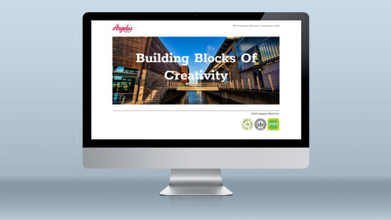 Desktop monitor displaying the Angelus Block website homepage, featuring a large image of a modern architectural building with the headline “Building Blocks Of Creativity” overlaid on the photo.