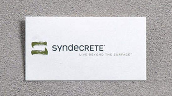 Syndecrete logo with a green, abstract brushstroke icon beside the name in modern type. Tagline reads “Live Beyond the Surface®.”