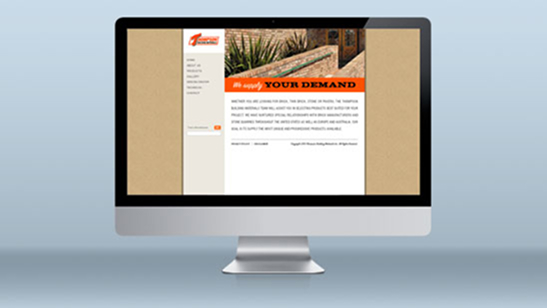Desktop monitor displaying the Thompson Building Materials website homepage, featuring the phrase “We supply YOUR DEMAND” in bold orange text above a short company description and an image of a brick and stone landscape wall.