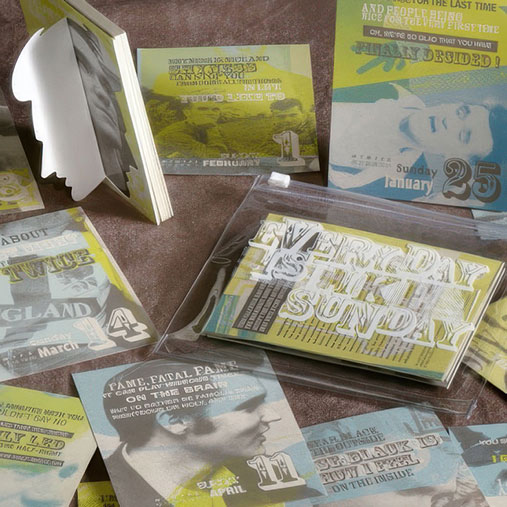 A collection of mixed-media promotional prints themed “Everyday Is Like Sunday,” displayed on a fabric surface. The set includes postcards, a booklet with a die-cut silhouette profile, and layered designs featuring bold typography, dates, and vintage-style photographs in muted blue, green, and yellow tones. The graphics evoke a nostalgic, collage-like aesthetic.